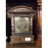 20TH CENTURY COMPOSITE MANTEL CLOCK IN STAINED WOODEN CASE, THE BRASS DIAL WITH ROMAN NUMERALS AND