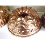 A VINTAGE COPPER JELLY MOULD OF CIRCULAR FORM, WITH A RECESSED AND ROSETTE TYPE MOULDED CENTRE, 8