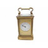 Late 19th or early 20th century French brass carriage clock, with circular enamel dial, fitted