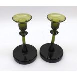 Pair of green glass candlesticks of circular form, the bases with ground pontil marks, no makers