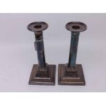 Pair of silver plated column formed candlesticks, with removable nozzles, raised on spreading square