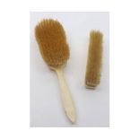 Two 19th century ivory backed dressing table brushes, largest 10" long