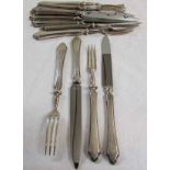 Six each George V dessert knives and forks, each with hard soldered and shaped handles, Sheffield