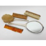 George VI silver backed five-piece dressing table set comprising mirror, comb, and three brushes,