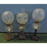 Mixed Lot: three Victorian oil lamps fitted with frosted glass shades and raised on cast metal