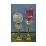 Two brass based oil lamps, both with later electrical conversion, one fitted with cranberry shade,
