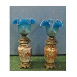 Unusual pair of oil lamps, fitted with clear glass chimneys, frilled blue glass shades and brass