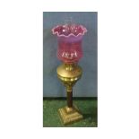 Victorian oil lamp, with clear glass chimney, cranberry tinted shade and brass and copper column