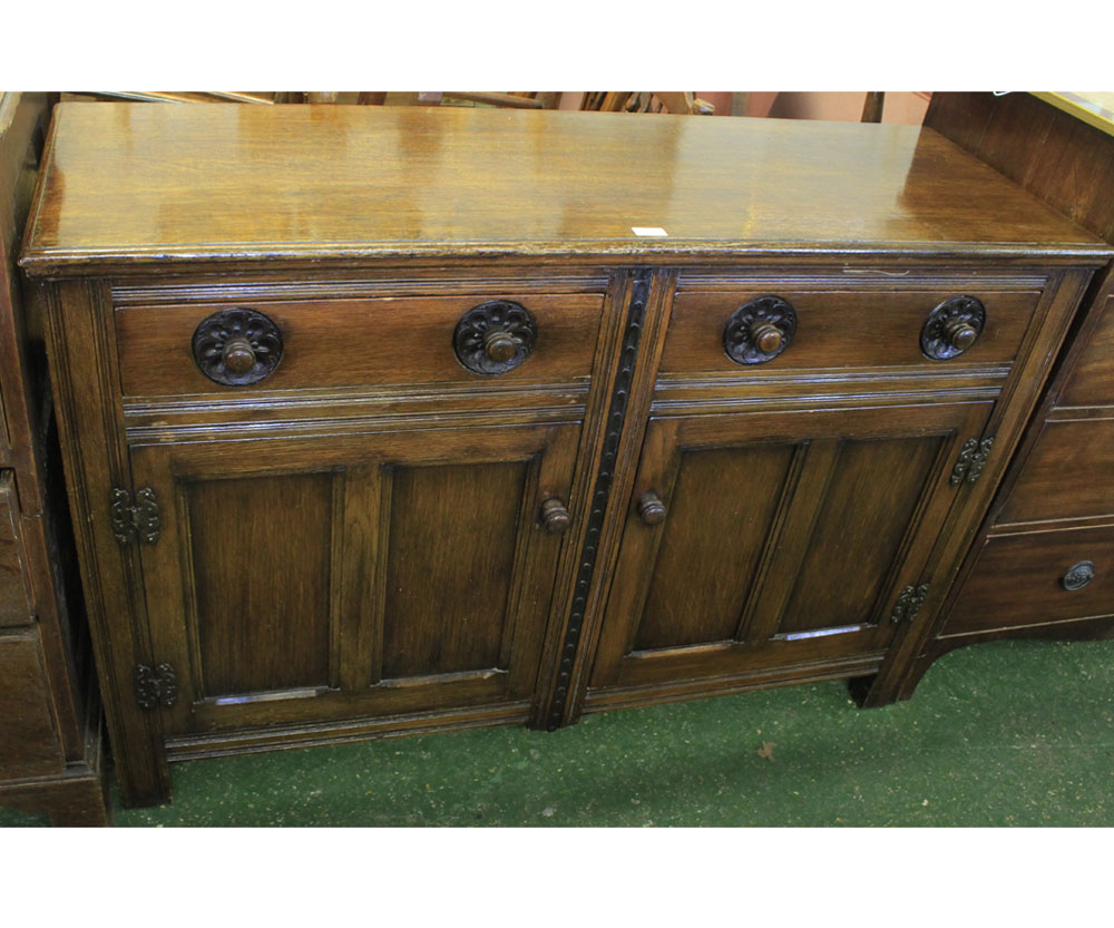 20th century oak two-door two-drawer sideboard of carved detail, 54" wide