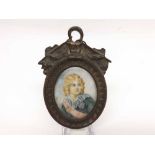 A small 19th century framed Continental portrait plaque of a young boy in period dress, bears