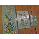 Three 20th century enamel and hammered pewter-backed panels, decorated with various sprays of