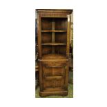 Reproduction oak corner cabinet with three shelf top over a single panelled door and bracket feet