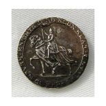 Rough cast silver medallion depicting a hooded and mounted figure and signed to the border “