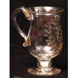 George IV glass tankard of baluster form with scrolled handle raised on a short base inset with a