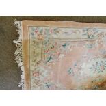 An Indian or Chinese thick pile wool rug, typically decorated with central panel of foliage and