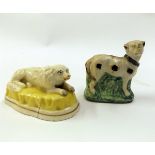 Two early 19th century Staffordshire models of dogs, one standing on a green base and with ochre