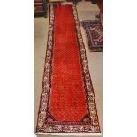 Caucasian runner with double gull border, central panel of geometric designs, mainly red field, 13ft