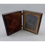 19th century mounted photographic image of two young girls in black composition hinged case, 5 ½”