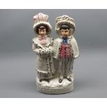 19th Century Staffordshire figure group, Darby and Joan, raised on an oval plinth base, 10” high