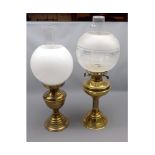 Two vintage brass based oil lamps with globe shades, largest 21" high in total (2)