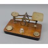 Vintage brass postal scales and weights, on a hardwood base