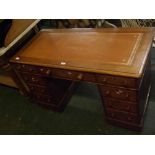 Late 19th century oak twin pedestal desk, of nine drawers with turned knob handles, inset with brown