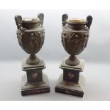 Pair of Grecian style table top urns, raised on slate and marble inlaid plinth bases, 16 = high