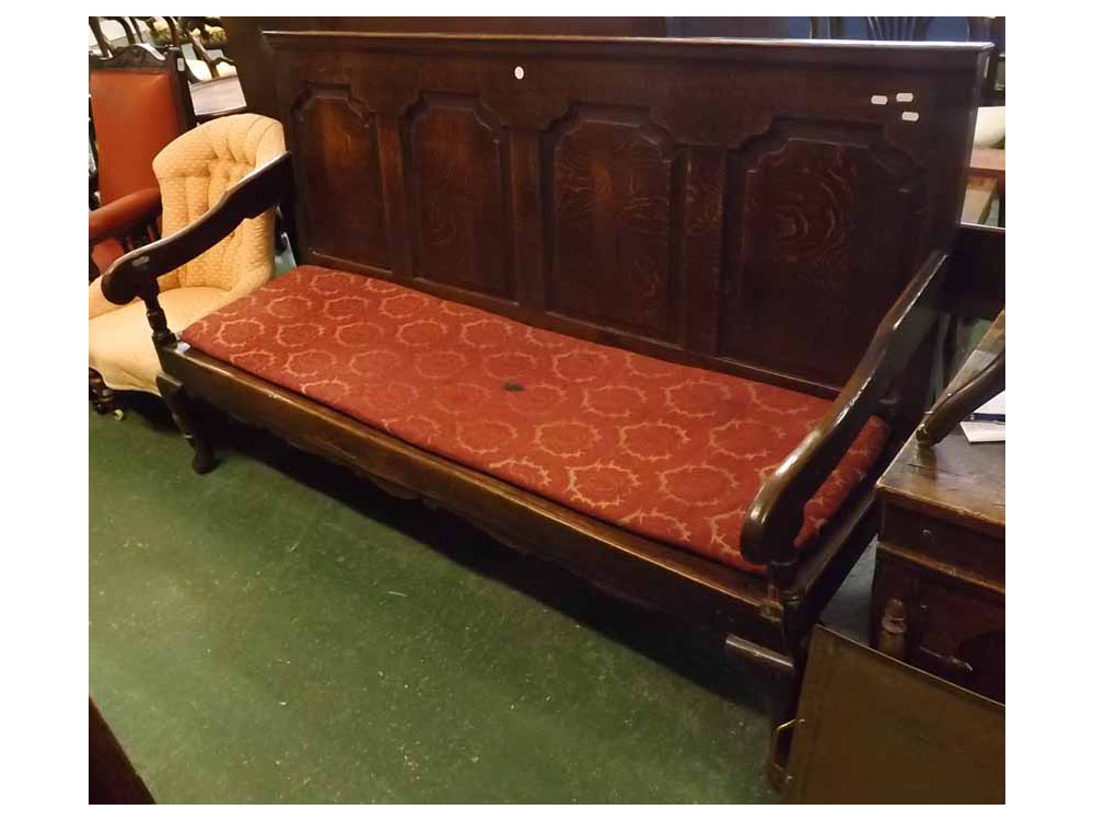 Large 19th century oak settle, the four panelled back over a base with short cabriole legs and later