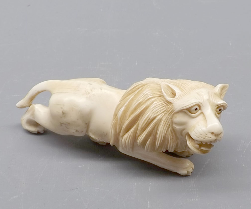 Oriental ivory carved model of a lion, 5" long