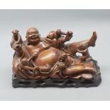 Oriental hardwood model, of a reclining Buddha and children, on stand, 8 1/2" long