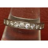 Precious metal half eternity ring, set with eleven small single cut stones, stamped "18ct", finger