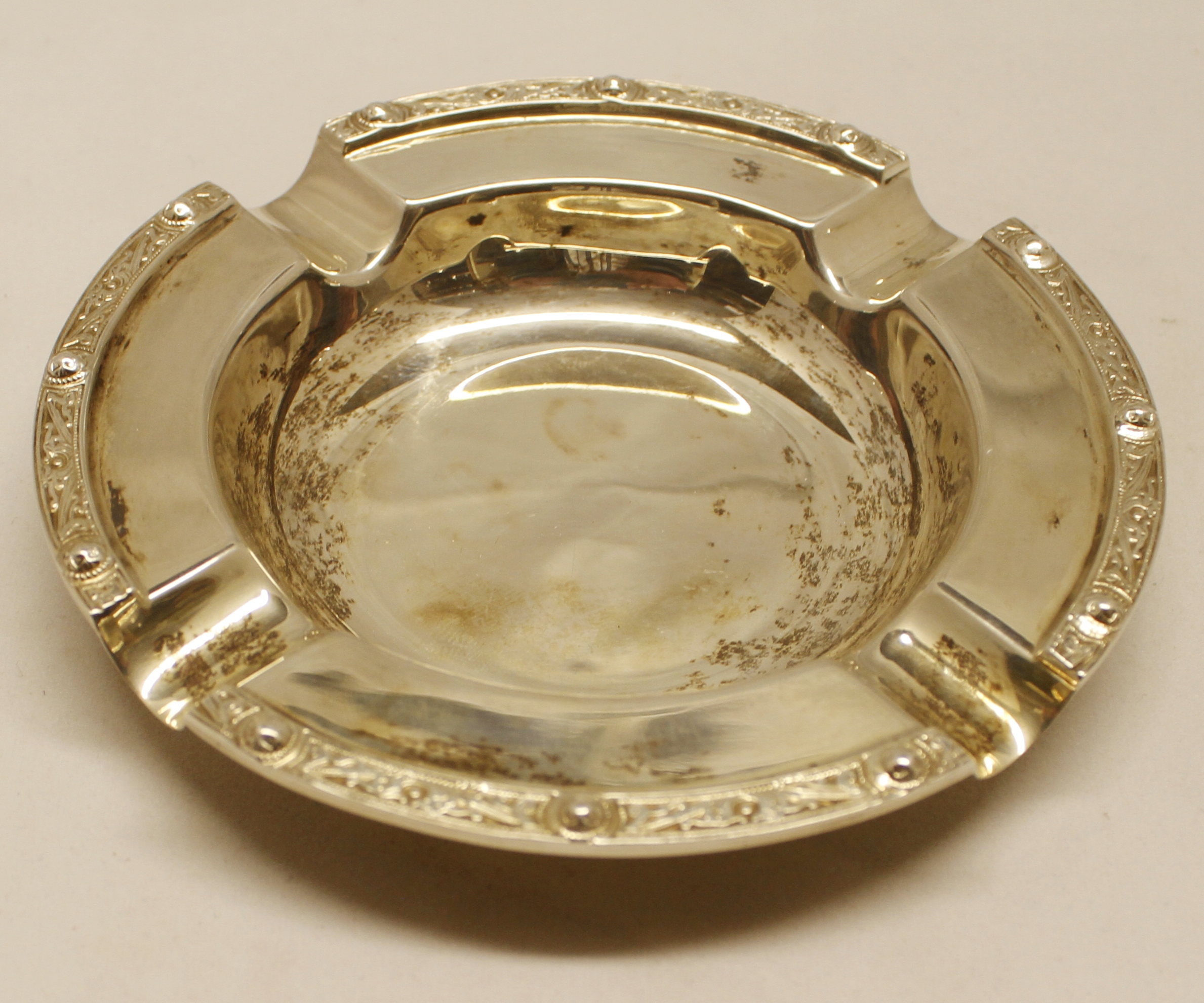 Elizabeth II circular ashtray, with cast and applied Celtic border and polished field, diameter 4