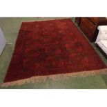 20th century red ground Middle Eastern floor rug decorated with various geometric designs and