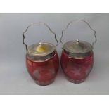 Pair of cranberry glass and silver plated mounted biscuit barrels