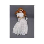 Schoenau & Hoffmeister porcelain faced painted doll with glass eyes in a Christening gown, measuring