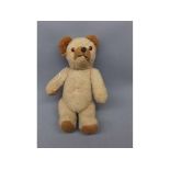 Mid-20th century small straw stuffed teddy bear with moveable arms and legs with squeaker and