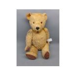 Mid-20th century teddy bear with jointed arms and legs, fitted with glass eyes, measuring approx 17