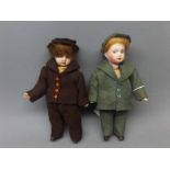 Two dolls house porcelain dolls, one in a green velour suit and the other one in a brown suit with