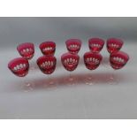 Set of ten cranberry bowled and facetted wine glasses, with clear stems and feet