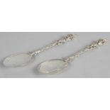 Pair of late Victorian silver serving spoons with plain oval bowls, the cast stems with seated