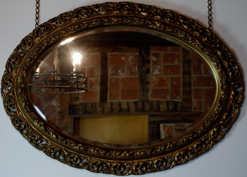 Early 20th Century carved gilt gesso framed oval wall mirror in Rococo style, having pierced