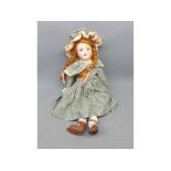 Heubach bisque headed doll with glass eyes and painted face, in a decorative floral dress, measuring