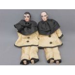 Near pair of mid-20th century porcelain and painted face dolls, modelled as clowns, in silk