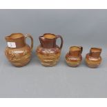 Four 19th century pottery jugs, decorated with sprigged detail