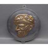 Cast metal wall plaque depicting military figure, 9" diameter
