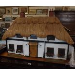 Contemporary thatched doll's house with fitted and furnished interior, 40" long