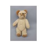 Mid-20th century small straw stuffed teddy bear with moveable arms and legs with squeaker and