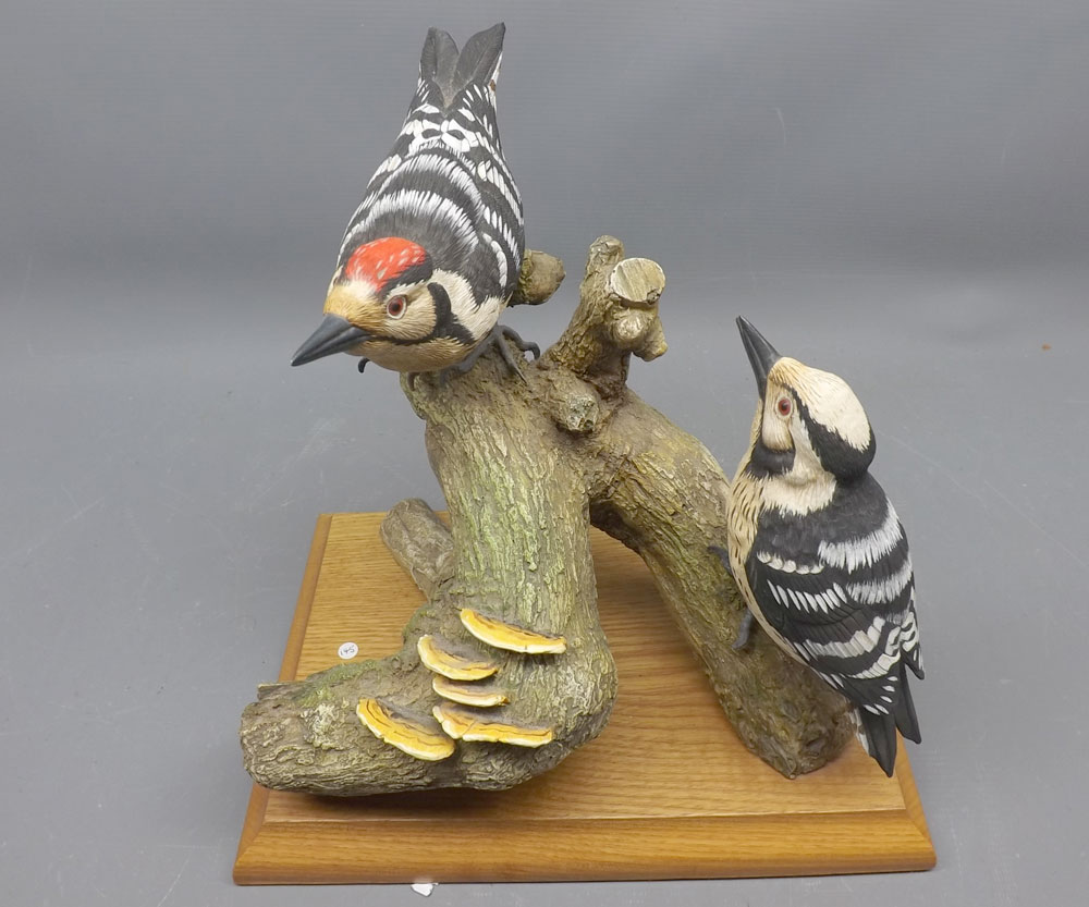 Resin model of two woodpeckers, on a tree trunk