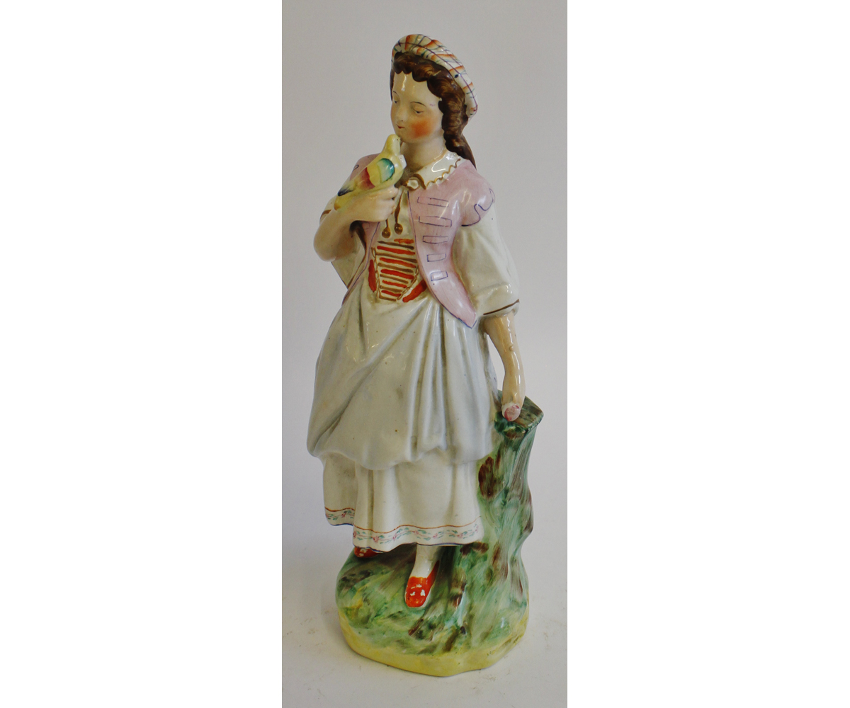 19th century Staffordshire figure, of a girl with dove perched on her right hand, wearing a puce