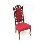 Victorian rosewood simulated nursing chair, the back moulded with "C" scrolls and raised on